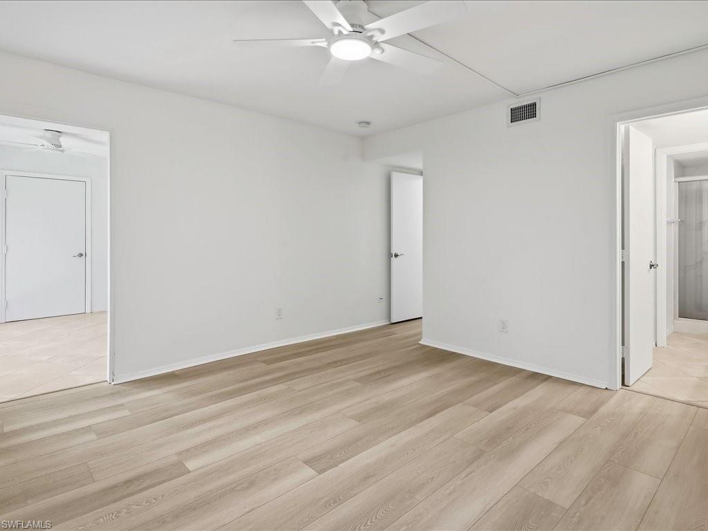 1001 Foxfire Lane, Unit 204 Naples, FL 34104 - Photo 15 of 35 an empty room with a ceiling fan and wooden floor