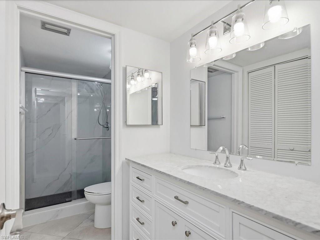 1001 Foxfire Lane, Unit 204 Naples, FL 34104 - Photo 16 of 35 a bathroom with a granite countertop sink toilet and shower
