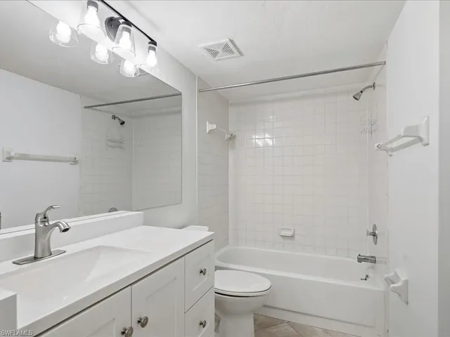 a bathroom with a sink mirror toilet and bathtub
