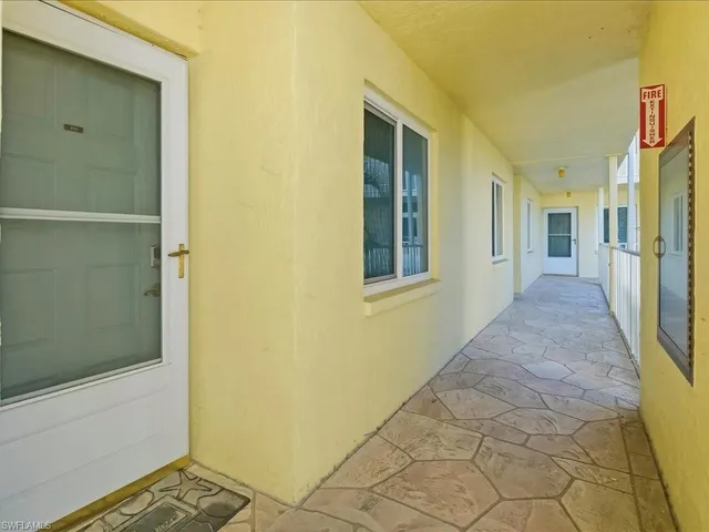 a view of a hallway with wooden floor and a bathroom