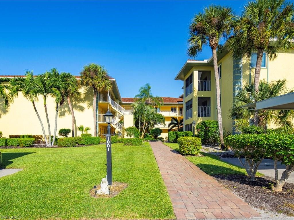 1001 Foxfire Lane, Unit 204 Naples, FL 34104 - Photo 23 of 35 a front view of a residential houses with yard and green space