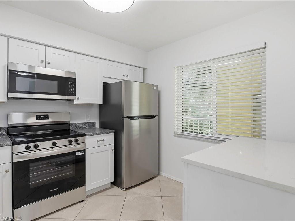 1001 Foxfire Lane, Unit 204 Naples, FL 34104 - Photo 3 of 35 a kitchen with a refrigerator stove and microwave