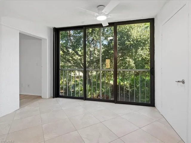 a view of an empty room with wooden floor and doors