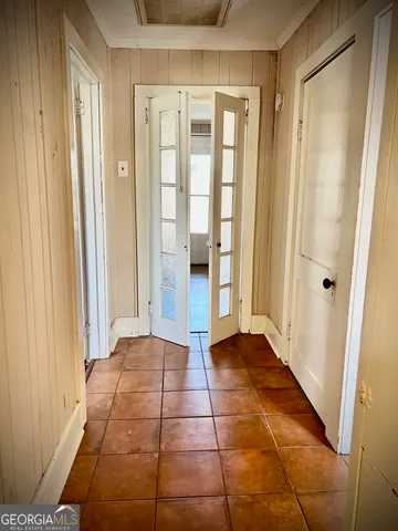 a view of a hallway with wooden floor and a bathroom