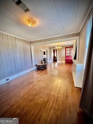 a view of a room with wooden floor and furniture