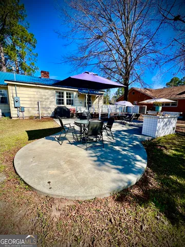 a view of a house with backyard swimming pool and sitting area