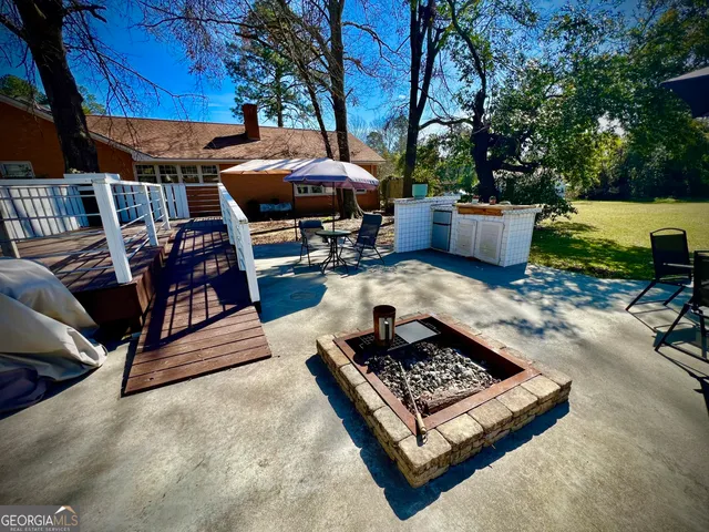 a view of a backyard with sitting area furniture and a fire pit