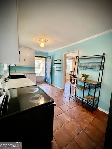 a kitchen with a sink a counter top space and a view of living room