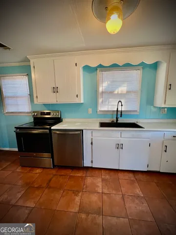 a kitchen with stainless steel appliances a stove a sink and a microwave