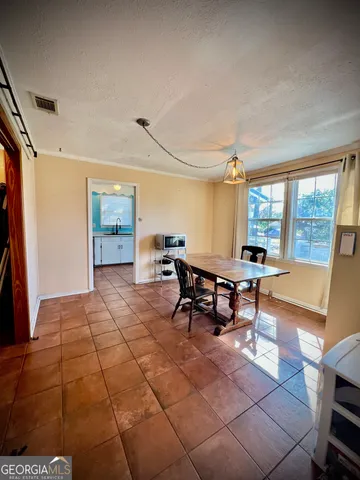 a living room with furniture a dining table and a large window