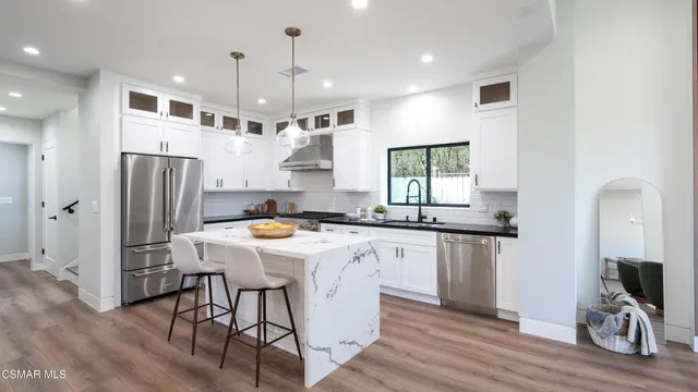 a view of a dining room and livingroom with furniture wooden floor a rug a potted plant and a chandelier