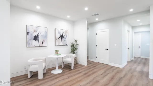 a dining room with wooden floor a chandelier a glass table and chairs