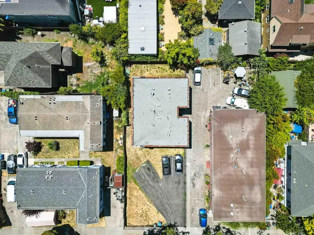 an aerial view of residential houses with outdoor space and parking