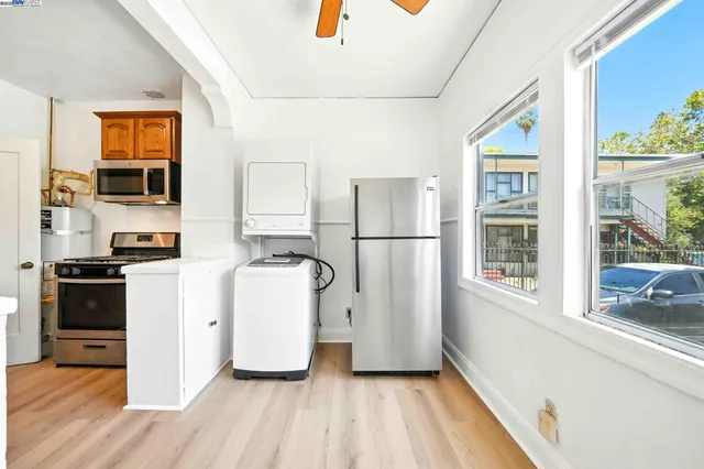 a kitchen with a refrigerator a stove top oven a sink and a large window