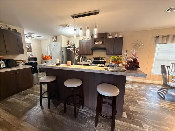a kitchen with stainless steel appliances granite countertop a sink stove and refrigerator