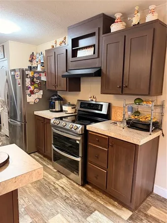 a kitchen with stainless steel appliances granite countertop a refrigerator a stove and a refrigerator