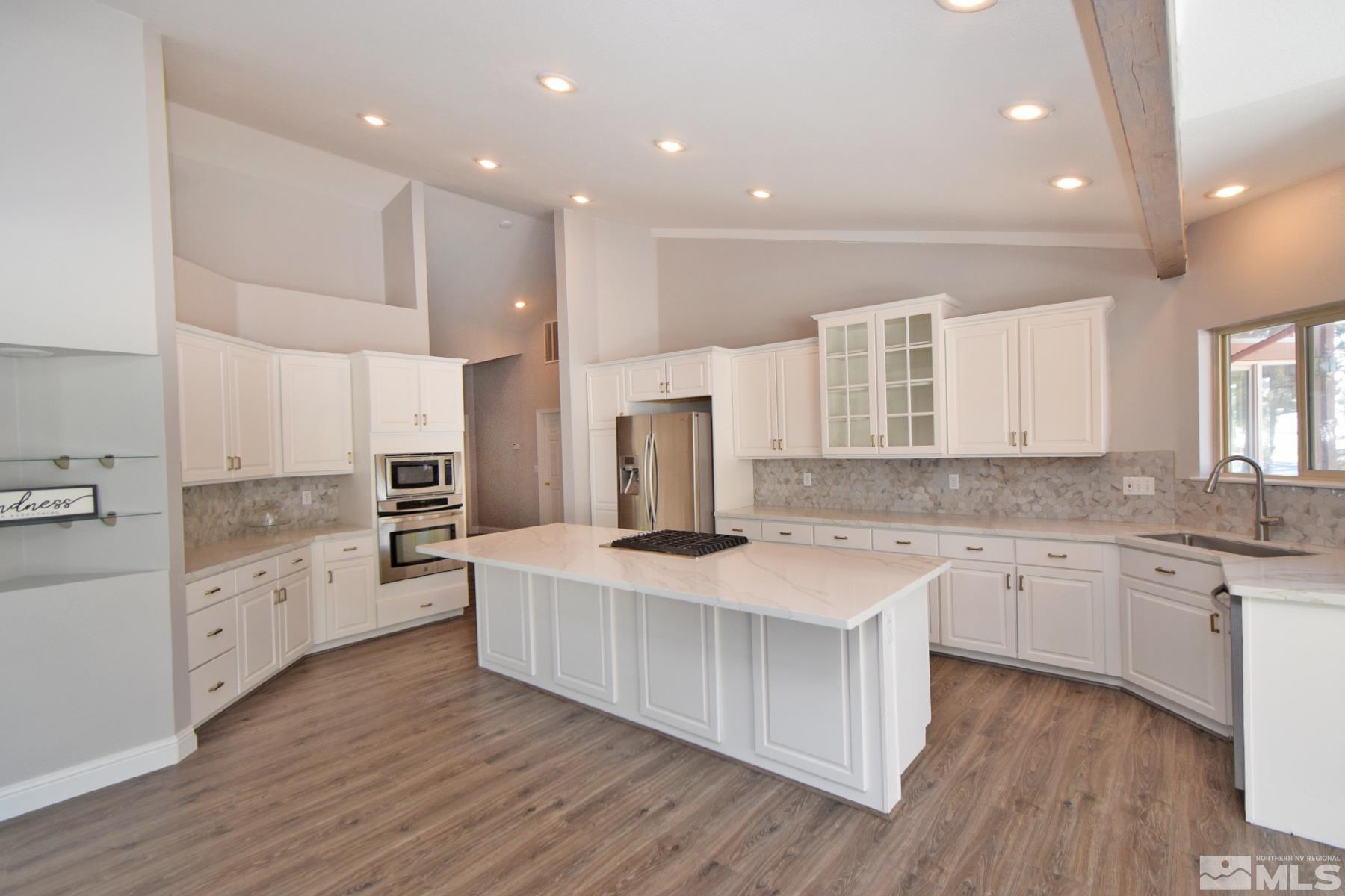 a large kitchen with cabinets a sink and appliances