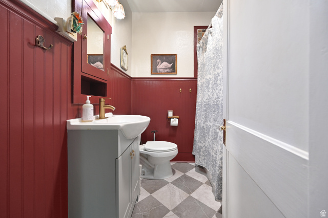 331 West 300 North Logan, UT 84321 - Photo 12 of 28 Bathroom featuring red wainscoting, a white vanity with an integrated sink, and a gold-finish faucet
