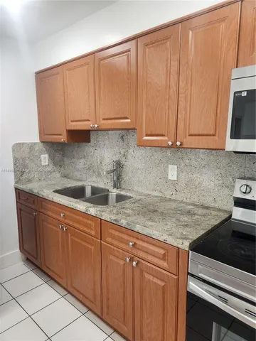 a kitchen with stainless steel appliances granite countertop a sink a stove and dishwasher with cabinets