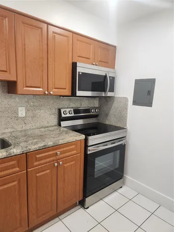 a kitchen with stainless steel appliances granite countertop a stove a microwave and a sink