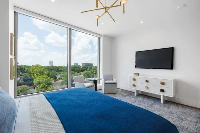 a view of a livingroom with furniture and floor to ceiling window