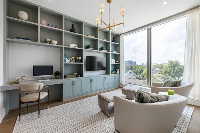 a living room with furniture a flat screen tv and kitchen view