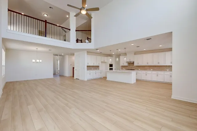 a view of a kitchen with kitchen island a sink wooden floor and a refrigerator