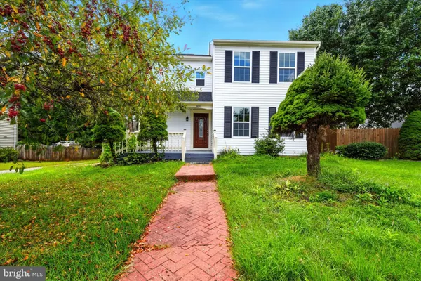 a front view of a house with a yard and trees