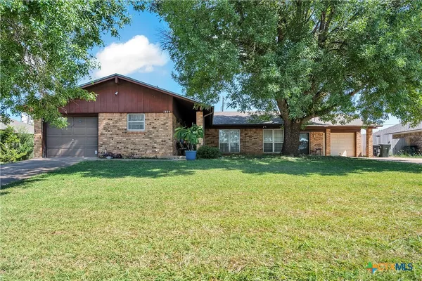 a front view of a house with a garden and yard