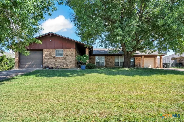 a front view of a house with a garden and yard