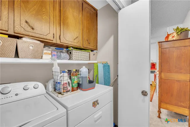 a utility room with fridge dryer and washer