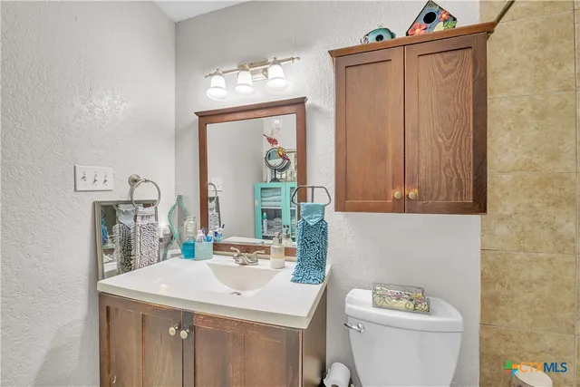 a bathroom with a sink a toilet and a mirror