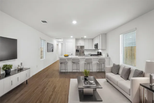 a living room with furniture and a wooden floor