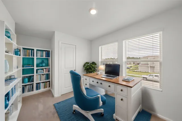 a view of a workspace with furniture and a window