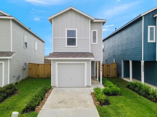 a front view of a house with a garden and garage
