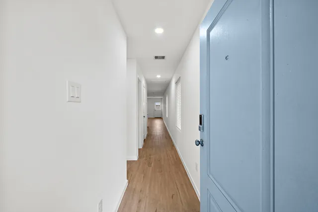 a view of a hallway with wooden floor