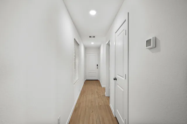 a view of a hallway with wooden floor