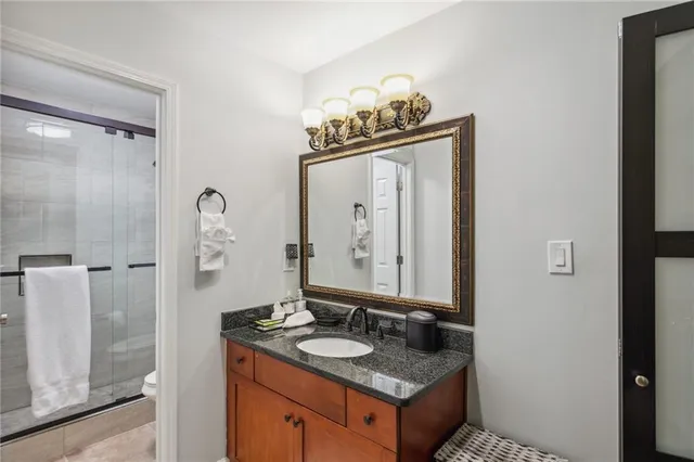 a bathroom with a granite countertop sink and a mirror