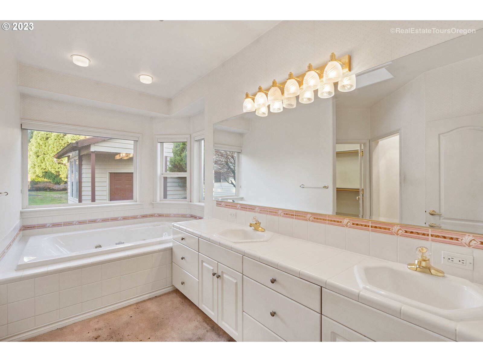 5161 Southeast Powell Valley Road Gresham, OR 97080 - Photo 15 of 32 a bathroom with a sink a large mirror and a bathtub next to a window