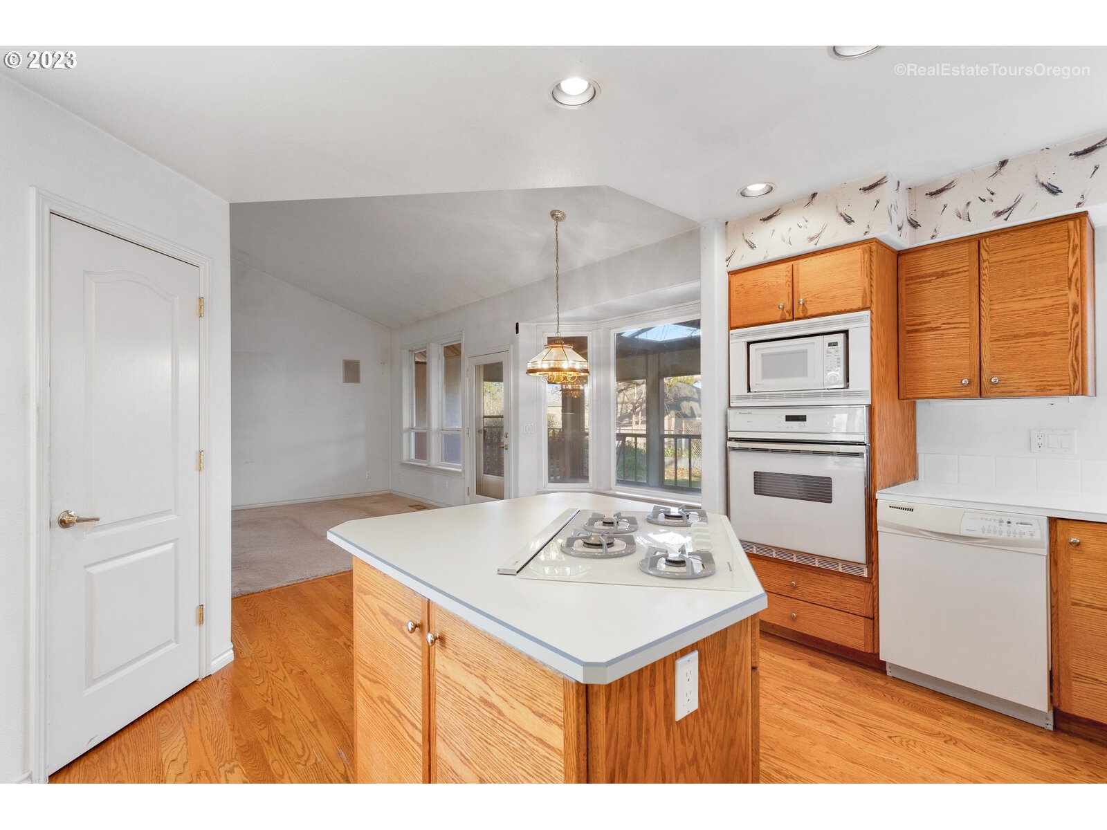 5161 Southeast Powell Valley Road Gresham, OR 97080 - Photo 5 of 32 a kitchen that has a kitchen island wooden cabinets and refrigerator