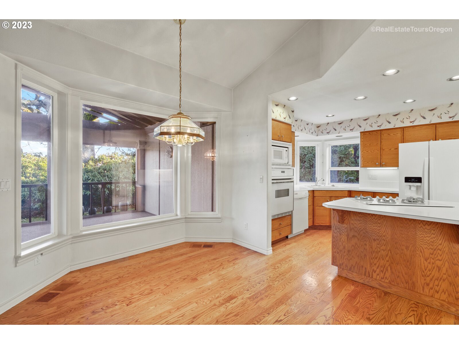 5161 Southeast Powell Valley Road Gresham, OR 97080 - Photo 6 of 32 a view of kitchen with stainless steel appliances granite countertop a refrigerator a sink dishwasher a stove and a dining table with wooden floor