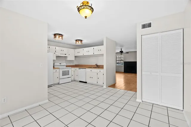 a kitchen with white cabinets and appliances