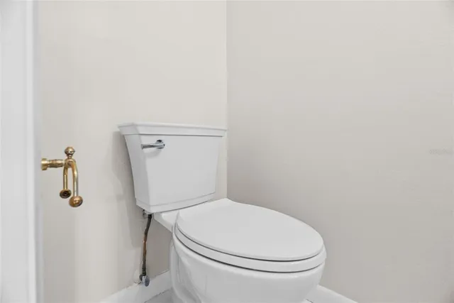 a white toilet sitting next to a shower