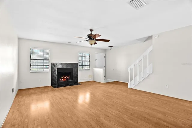 a view of an empty room with a fireplace and a window