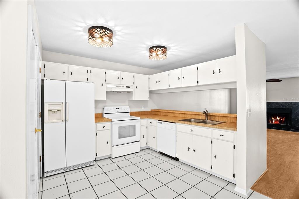 12668 Castle Hill Drive Tampa, FL 33624 - Photo 8 of 32 a kitchen with granite countertop white cabinets and white appliances