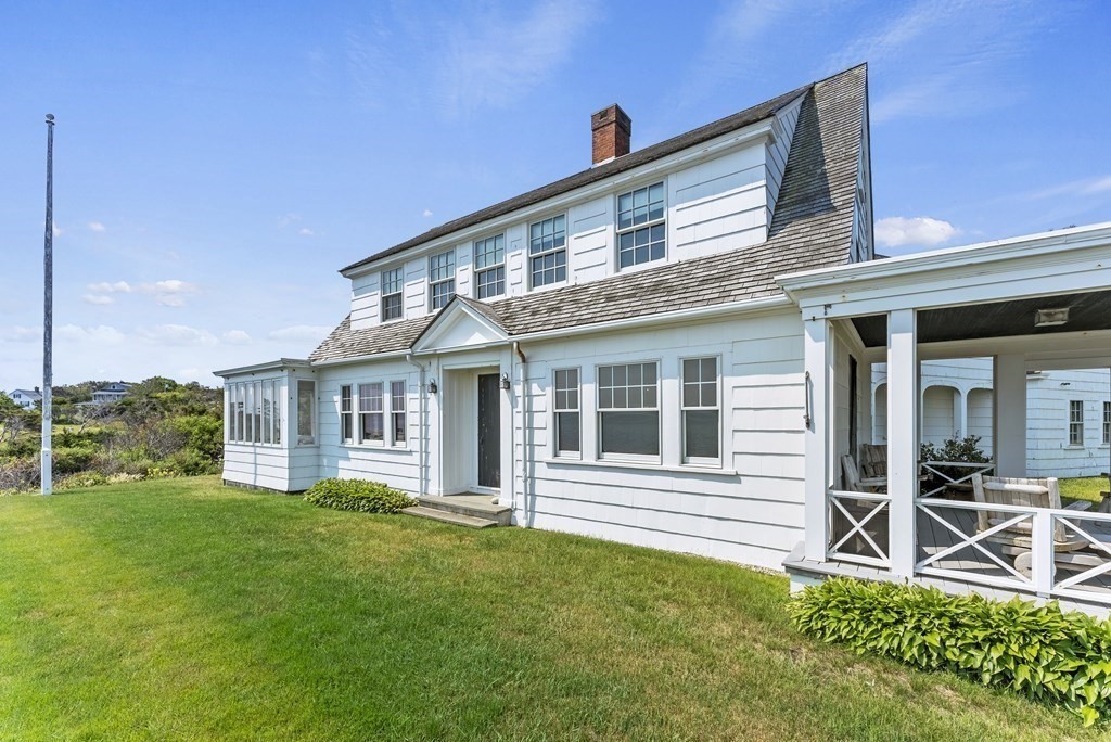 160 Clark Road Bourne, MA 02562 - Photo 13 of 42 a front view of a house with a yard table and chairs