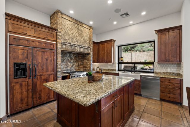 a kitchen with granite countertop stainless steel appliances a sink stove and refrigerator