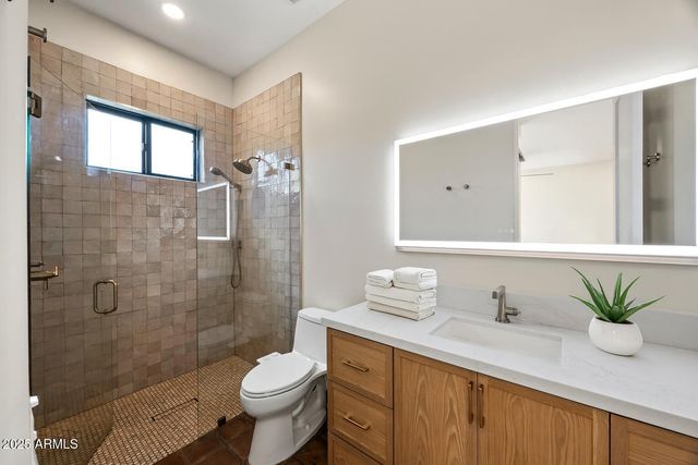 a bathroom with a granite countertop sink a toilet and shower