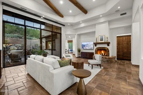 a living room with furniture a fireplace and a floor to ceiling window