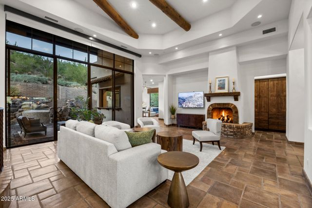 a living room with furniture a fireplace and a floor to ceiling window